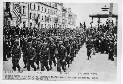 American troops march on a city street.