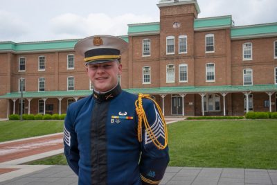 Hudson stands in his dress uniform in front of Lane Hall.