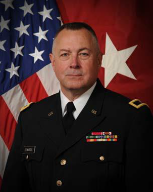 Portrait of Edwards in uniform with flags behind him