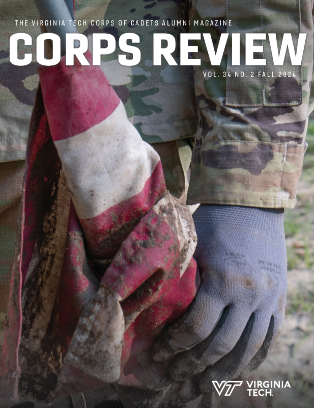 Front cover of magazine showing a cadet's arm and gloved hand holding a tattered and muddy American flag. The title of the magazine and text is in white letters and reads "The Virinig tech Corps of Cadets Alumni Magazine Corps Review volume 34 number 2 Fall 2024