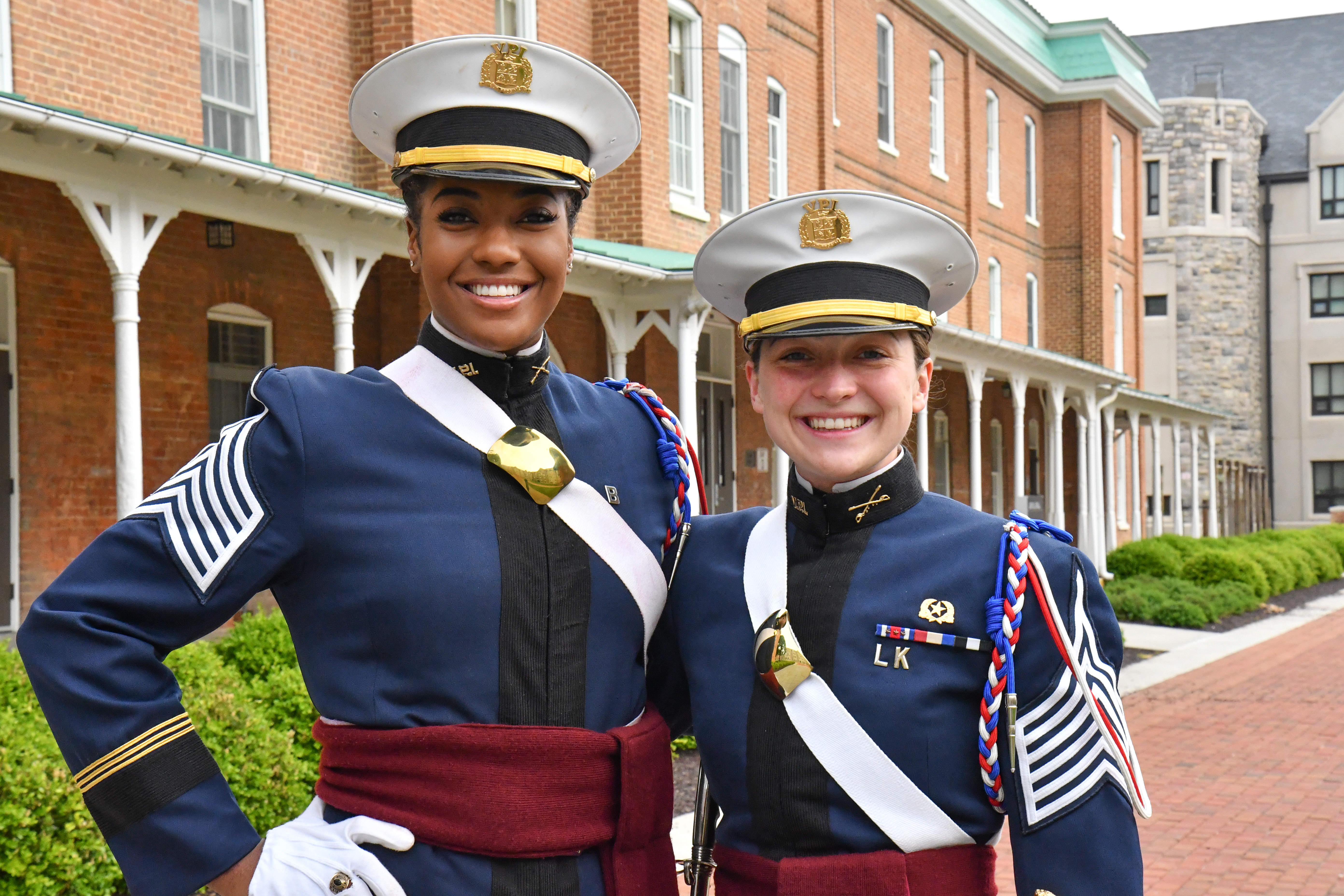 Brooke Johnson and Claire Seibel stand in front of Lane Hall in dress uniforms