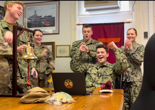 Midshipman Henry Driesen (seated) celebrates after selecting the USS Bainbridge (DDG-96) out of Norfolk, Virginia. Photo courtesy of Midshipman Zoe Lynes. 