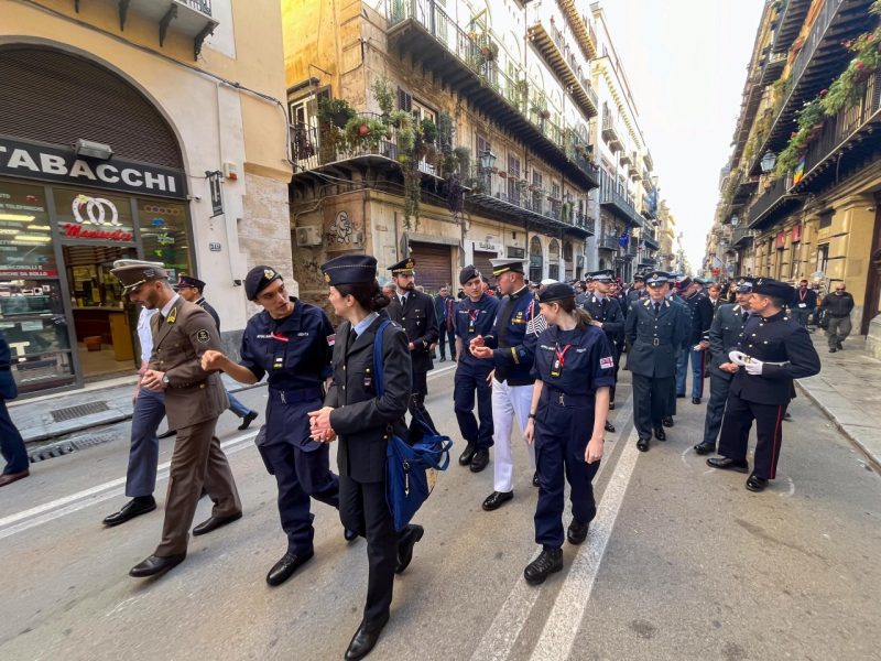 A large crowd of conference participants walk in the streets during the Walk for Remembrance & Peace. Cadet Lerner is in the second row in uniform talking to other participants.