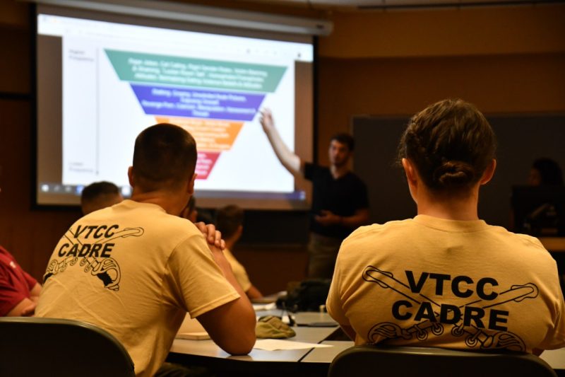 Two cadets look at a campus partner who is providing training on sexual violence prevention