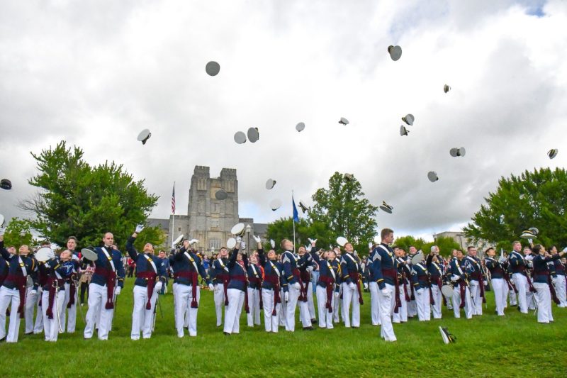 Graduating cadets throw their covers in the air in front of Burruss Hall after completing their last pass in review.