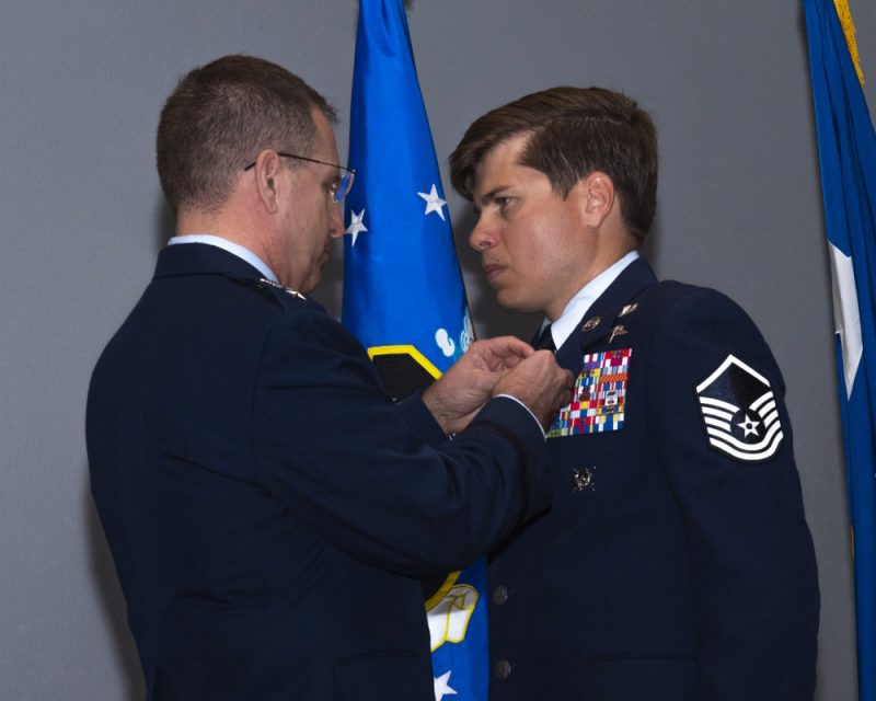 Master Sgt. John Grimesey ’14 (right) receives the medal.