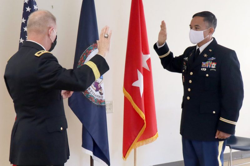 Maj. Waldon W. Jue ’01 (right) commissions as a cyber officer.