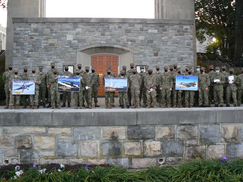 Midshipmen stand in a long line in front of the chapel.