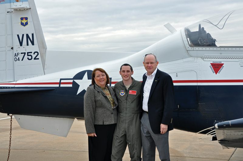 From left, Debbie, Ian, and Dan Tillotson pose in front of an aircraft.