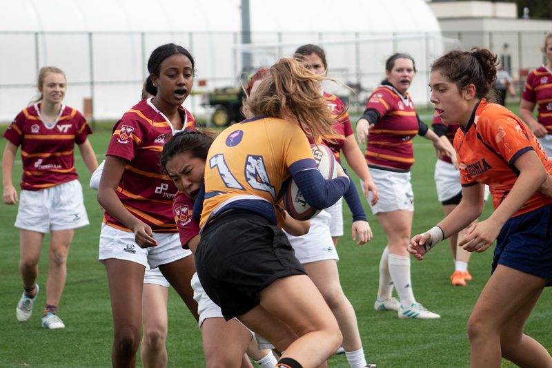 Cadet Grace Kim (at center) makes the tackle during a Women’s Rugby Club’s match.