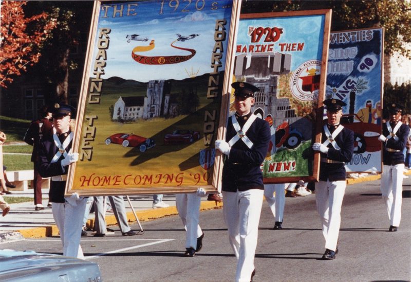 Cadets carry banners in the 1990 homecoming parade.
