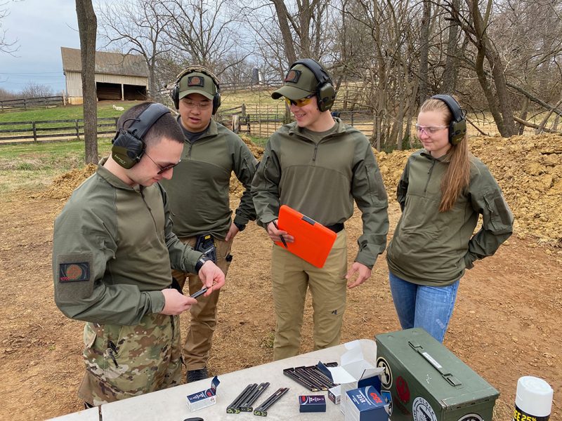 Four cadets practice at an outdoor shooting range.