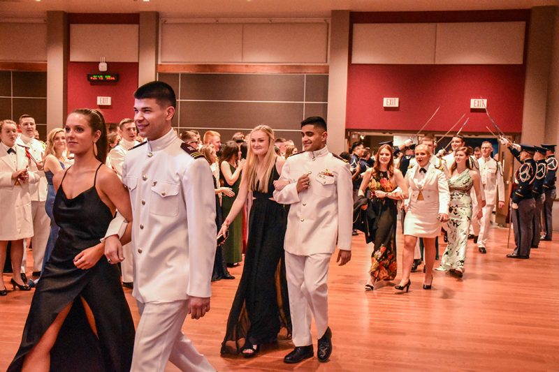 Seniors walk through a saber arch into the 2020 Military Ball.