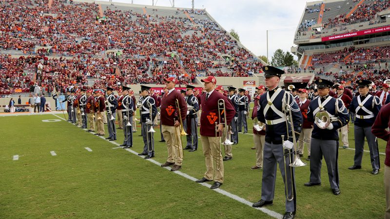 Current band cadets and Highty-Tighty alumni stand together on Lane Stadium at the start of the pre-game show.