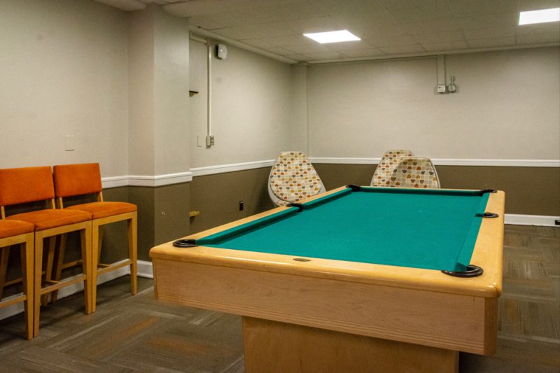 A larger lounge in Eggleston Hall has chairs and a pool table.