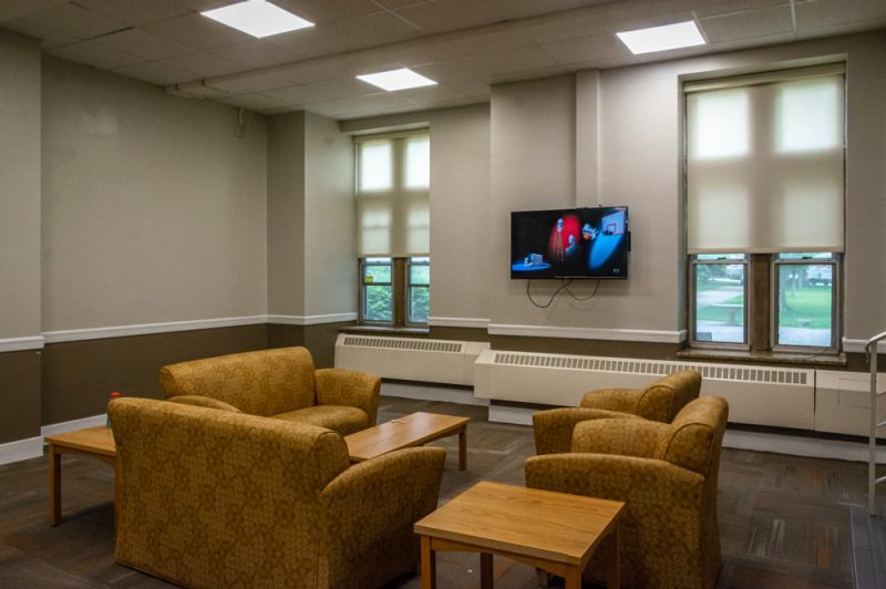 A larger lounge in Eggleston Hall has stuff furniture and a television.